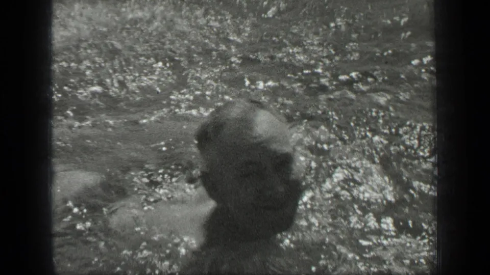 At Long Lake, Canada, a woman appears partly submerged in sunlit water in this 1939 8mm home-movie frame.