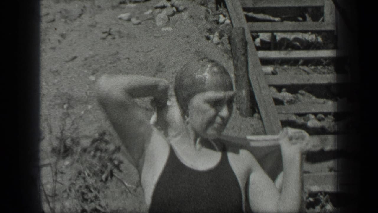 Woman in a dark bathing suit adjusts her swim cap near wooden steps.