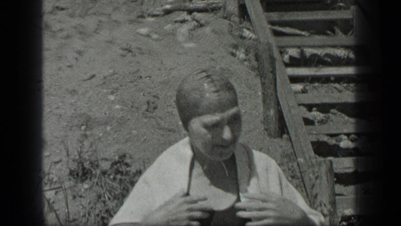 In the 1939 Long Lake home movie, the woman begins toweling off near the wooden steps after swimming.