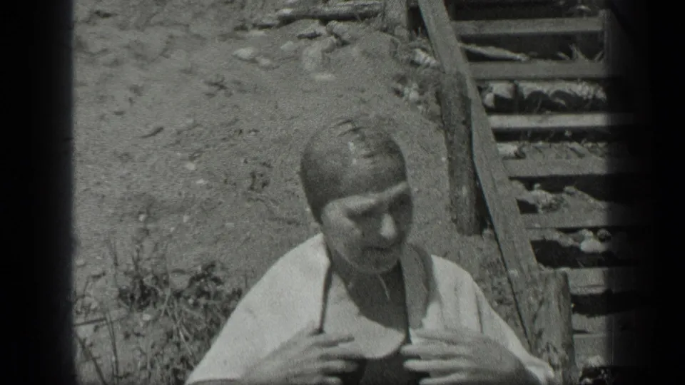 In the 1939 Long Lake home movie, the woman begins toweling off near the wooden steps after swimming.