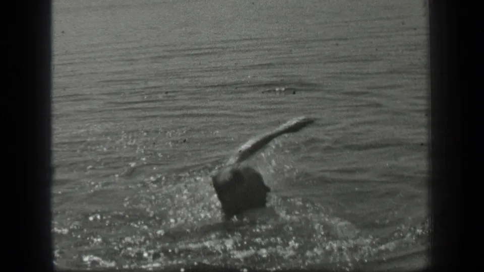 A 1939 Long Lake frame shows the woman swimming with one arm lifted above the sparkling water.