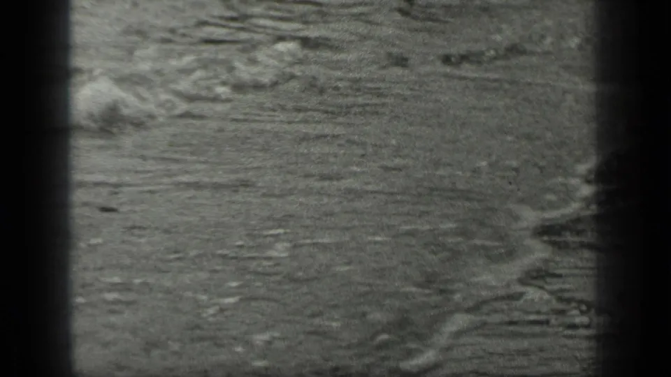 1939 Long Lake, Canada home-movie frame showing rippled shoreline water with small waves and dark film-gate borders.