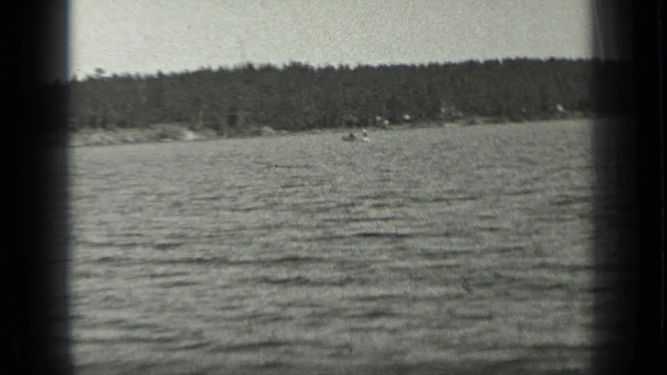 A wide 1939 Long Lake view shows rippled water, a low wooded shoreline, and soft 8mm frame edges.