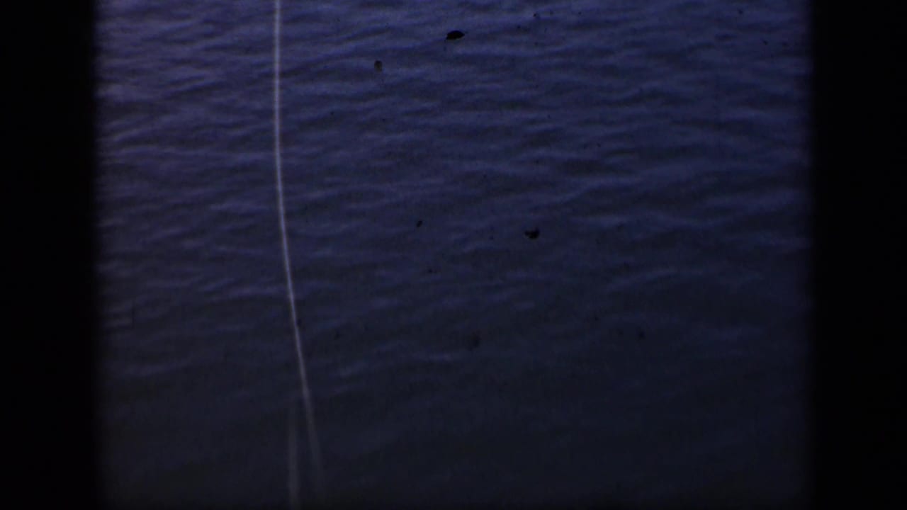 Rippled water with a thin fishing line crossing the frame and dark film borders.