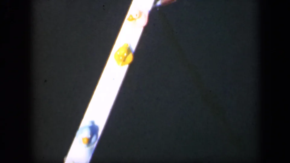 1948 Long Island 8mm frame showing a bright strip with yellow gum-like spots on a dark background.