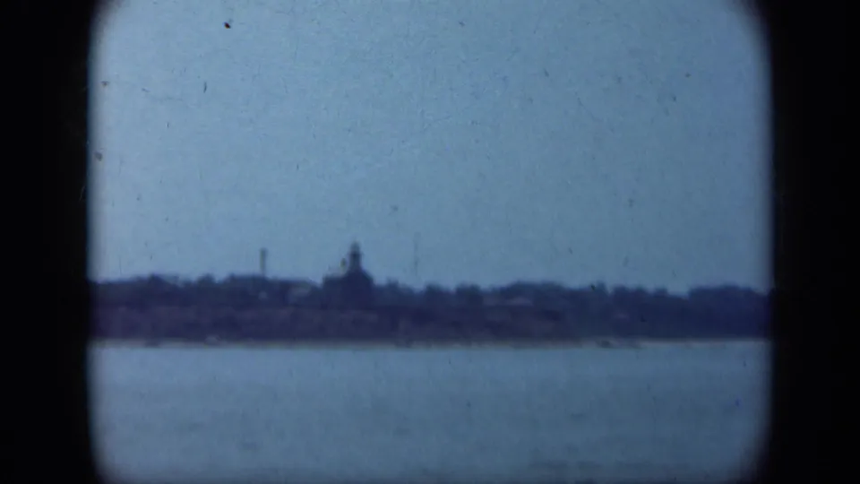 Blue-tinted 1948 Long Island boat view showing calm water, a distant shoreline, and a rounded tower-like silhouette.