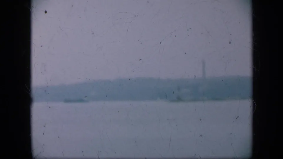 Long Island coastal view from 1948 showing broad water, a soft horizon, distant land, and faint structures through film wear.
