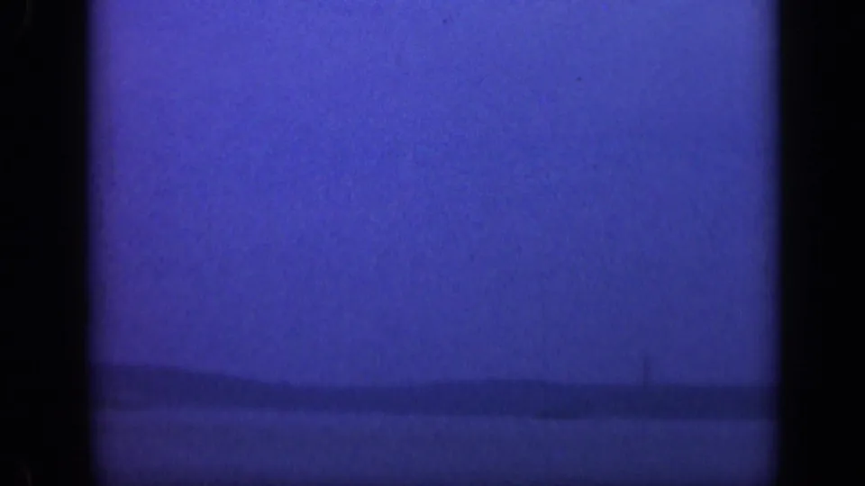 Blue-toned 1948 Long Island shoreline view, with calm water and a low horizon fading into a darker 8mm exposure.