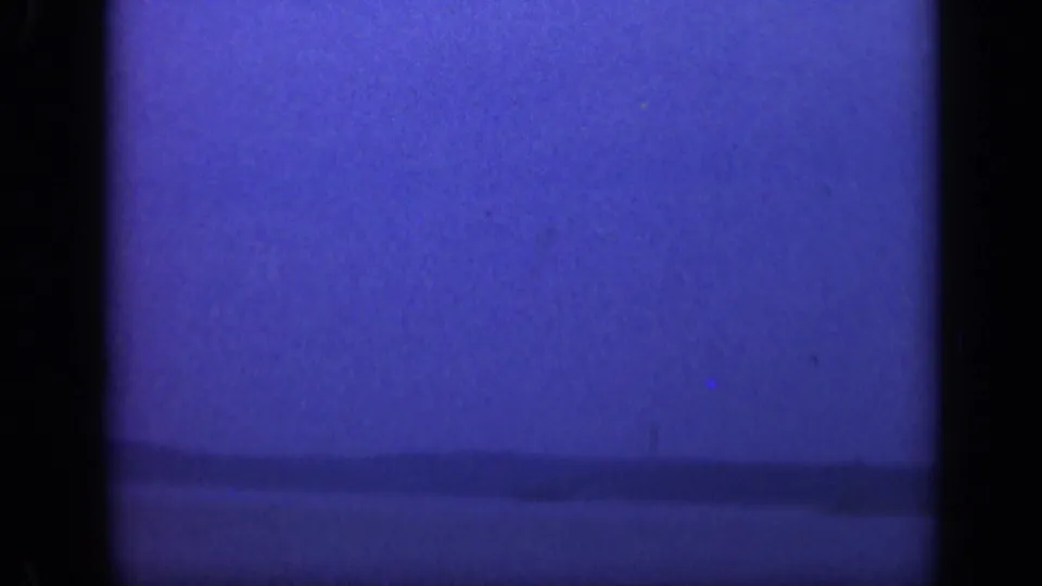 1948 Long Island 8mm frame showing a blue ocean horizon under a soft sky, bordered by dark film-frame edges.