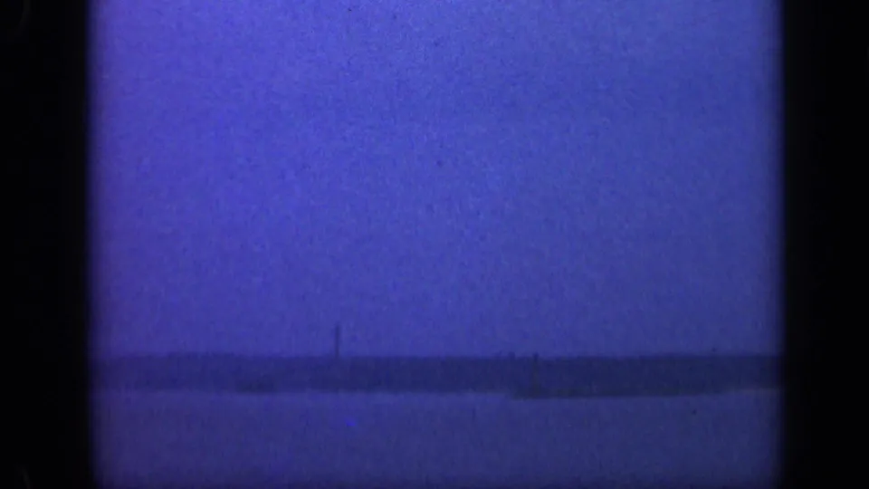 1948 Long Island home-movie frame of open water and a low horizon, softened by blue color shift and film grain.