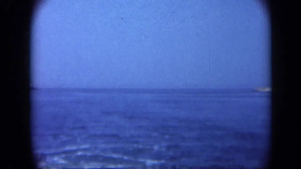 Blue 8mm view from Long Island showing calm ocean water, pale sky, and a faint distant horizon in soft focus.