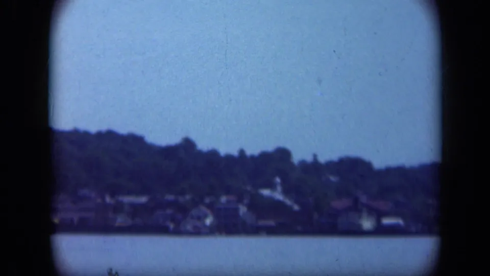 A distant Long Island waterfront neighborhood appears across calm water in this 1948 home-movie frame.