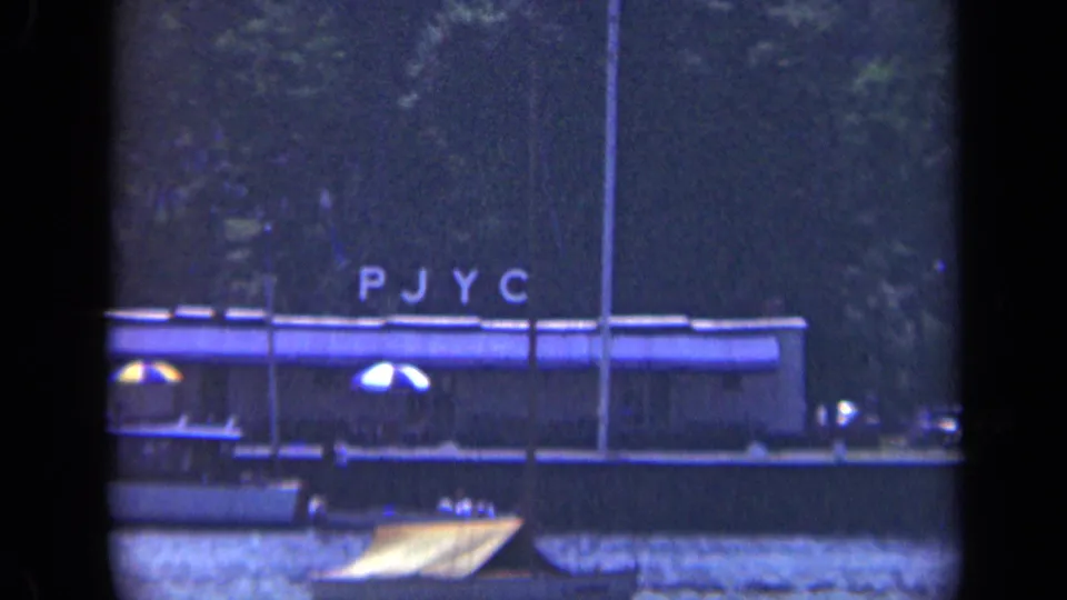 A grainy 8mm view shows the PJYC-lettered barge or vessel moving along a Long Island waterway in 1948.