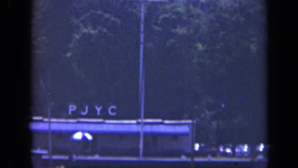 The final 1948 Long Island frame shows the PJYC-lit vessel lower in view, with trees, water, and heavy 8mm grain.