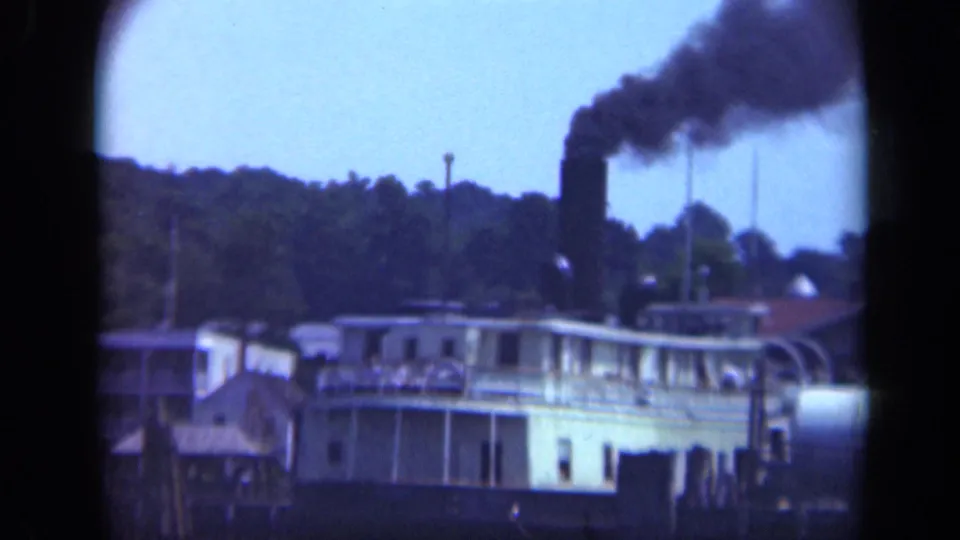 1948 Long Island waterfront view with a steamboat or ferry-like vessel releasing black smoke near shore structures.