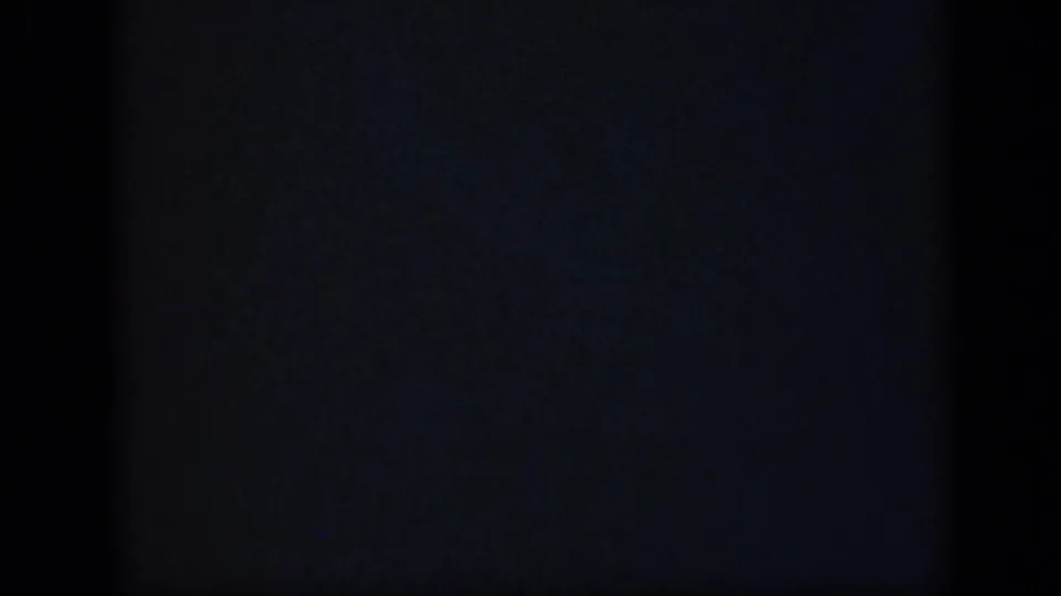 Blank 8mm frame from the 1948 Long Island clip, dominated by dark exposure, faint blue-gray grain, and vertical film borders.