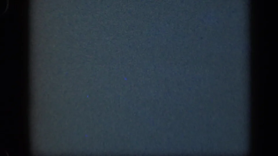 Blank 8mm frame from the 1948 Long Island clip showing blue-gray exposed film texture, grain, and dark side borders.