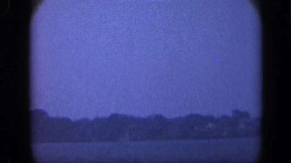 Blue-toned 1948 Long Island view across calm water toward a low, distant treeline at the island edge.