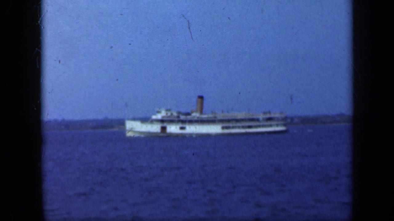 Steamship seen from a distance on calm blue water.