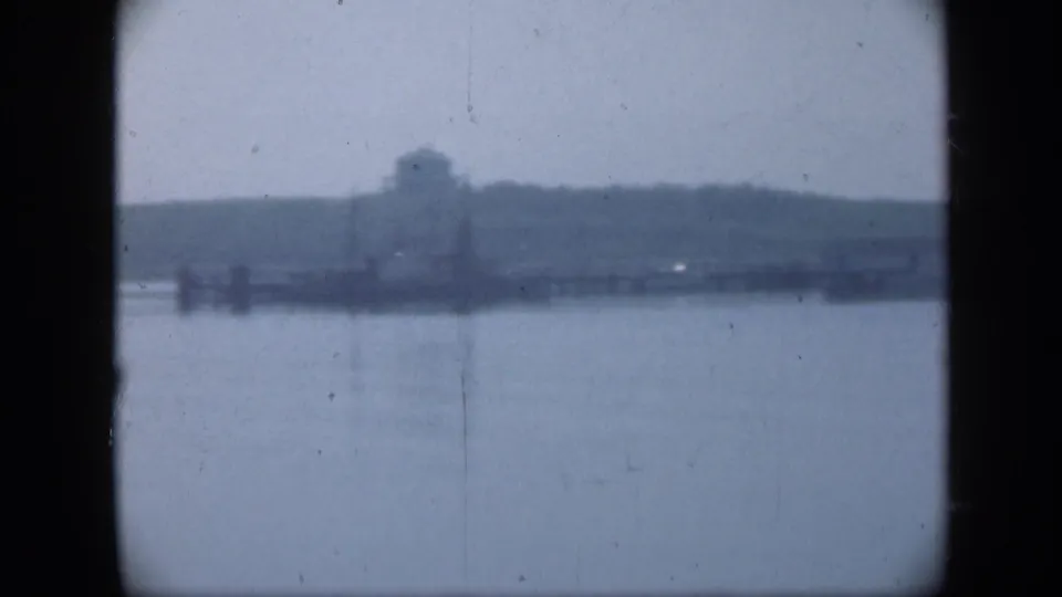 Soft 8mm view of a Long Island waterfront structure and dock-like forms across still water in 1948 footage.