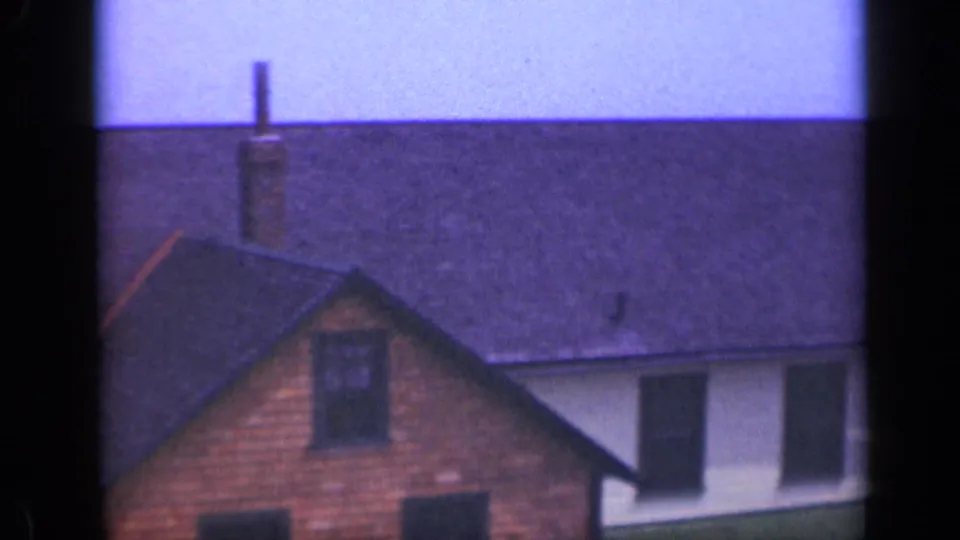 1948 Long Island frame of neighboring beach houses with dark roofs, brick chimney, wood siding, and pale sky.