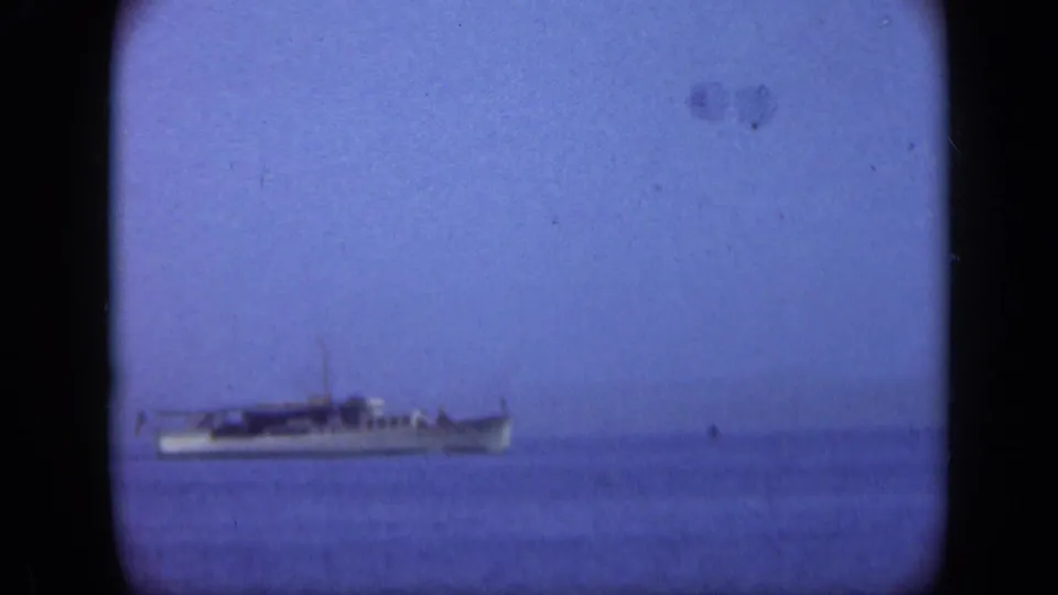 Distant vessel on open water in the 1948 Long Island coastal sequence, seen through soft 8mm exposure and grain.