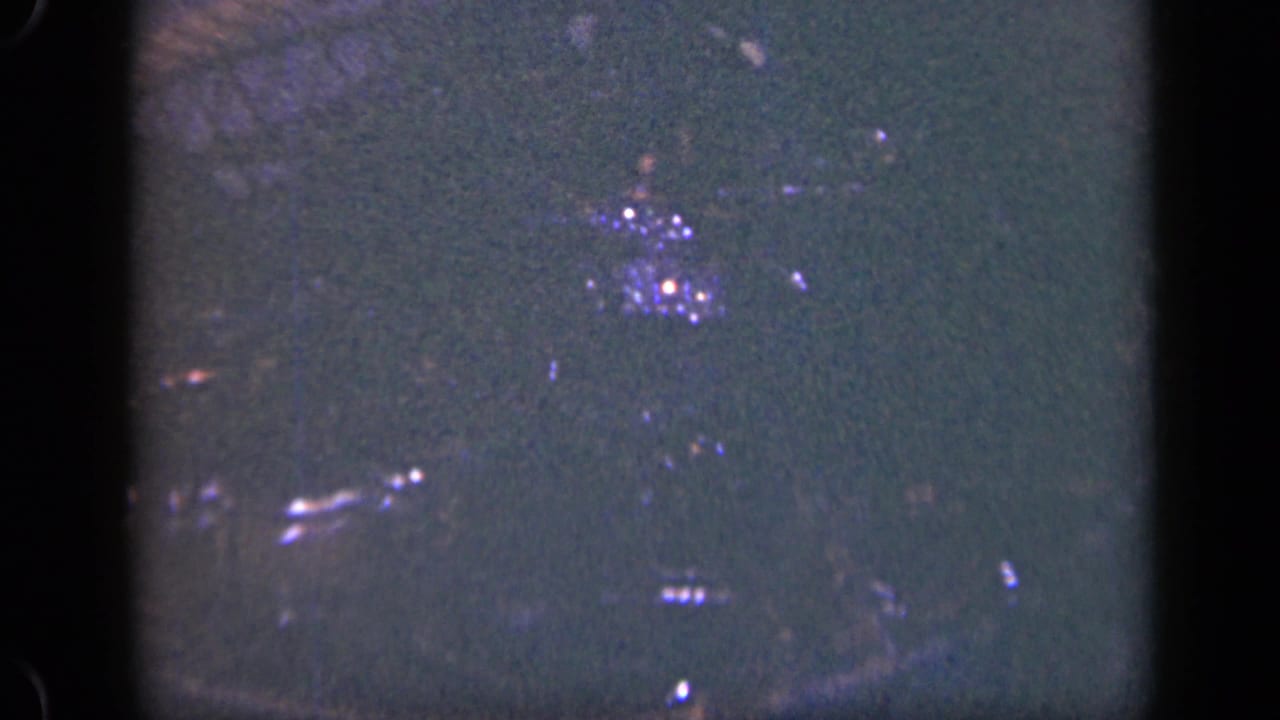Dark, soft view of wet lobsters inside a wire basket.