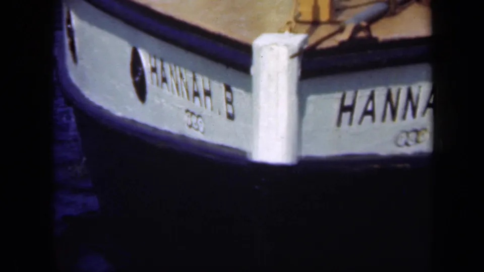 Close 1948 Long Island 8mm view of HANNAH.B's painted bow, black hull edge, and small visible insignia.