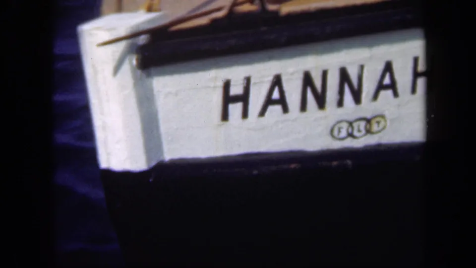 Tight 8mm frame of the boat's white bow with large HANNAH lettering, black trim, and small insignia below.