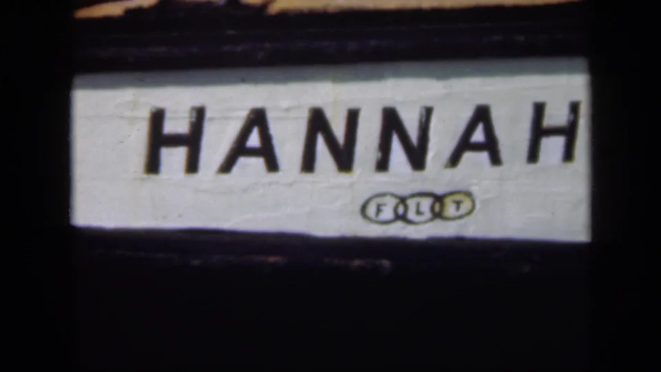 Extreme close 1948 Long Island 8mm view of the HANNAH boat name and small insignia on the white hull.