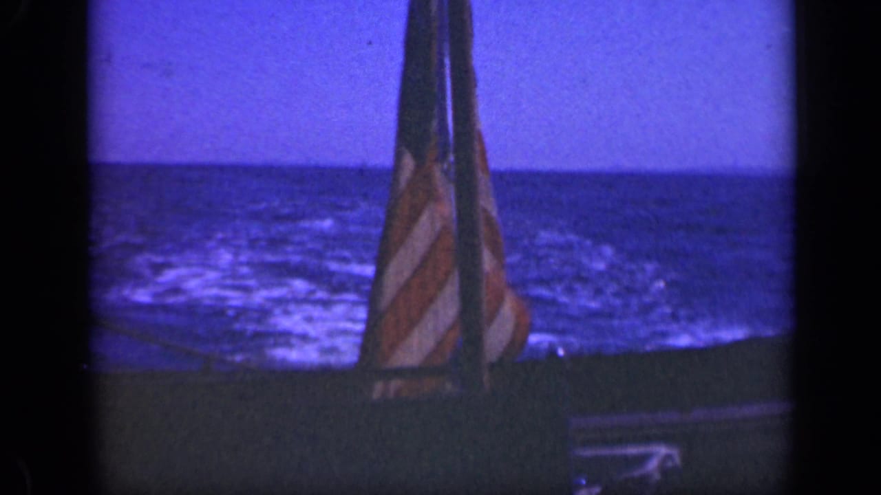 American flag on a boat with blue water and horizon behind it.