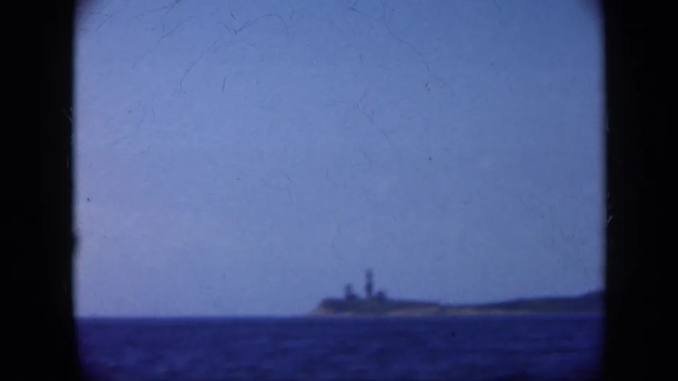 1948 Long Island 8mm frame with a distant ship or low island profile across open water.