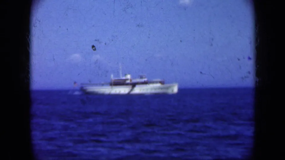 1948 8mm view of a white passenger ship on blue ocean water, with scratches and gate borders visible.