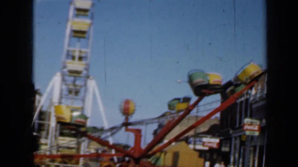 The clip ends on a closer 1958 Minnesota view of a red spinning ride and a white Ferris wheel against blue sky.