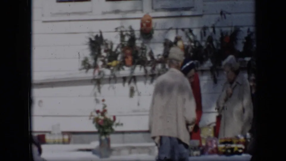 Women in coats and hats gather around a temporary flower stand in this 1959 Aledo, Texas home-movie frame.
