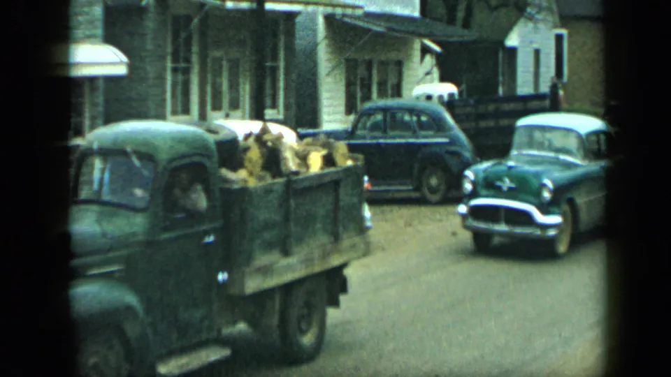 The pickup truck continues past the camera as a green sedan approaches or follows on the street in Aledo, Texas.