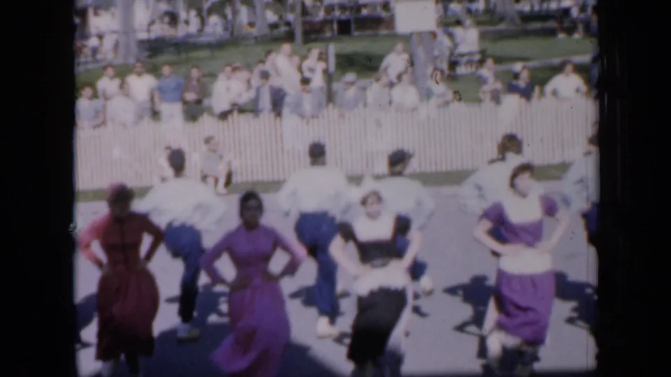 From a spectator viewpoint, the 1959 Iowa dance group faces away from the camera during a synchronized park performance.