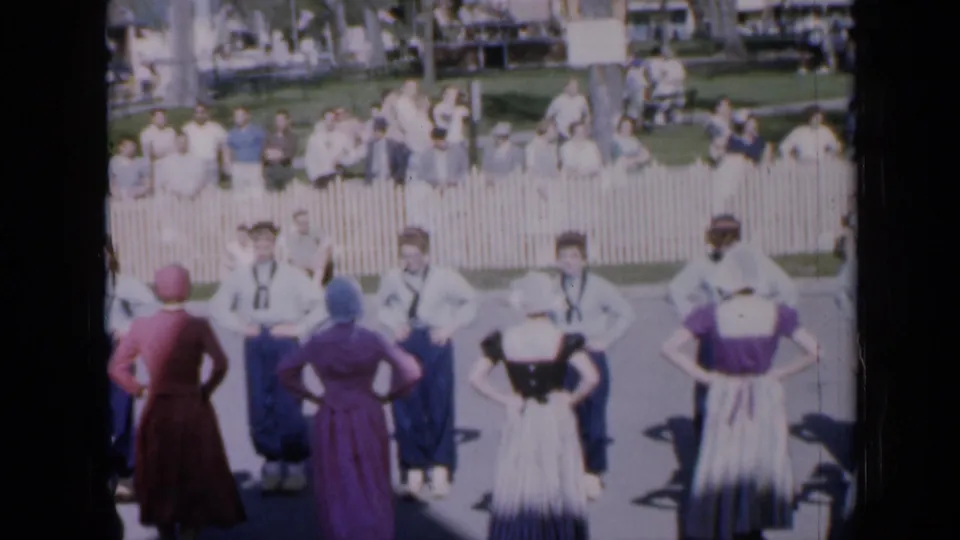 The 1959 Iowa park performance shows men in white shirts and women in long dresses facing into a dance formation.