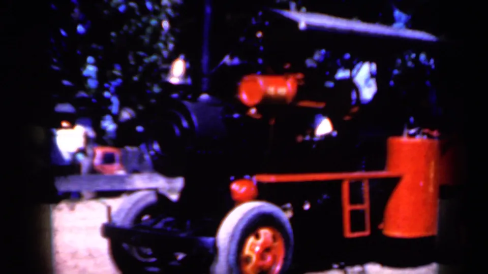 The vehicle fills more of the frame, with red trim and a black front set against deep tree shade at the outdoor Iowa location.