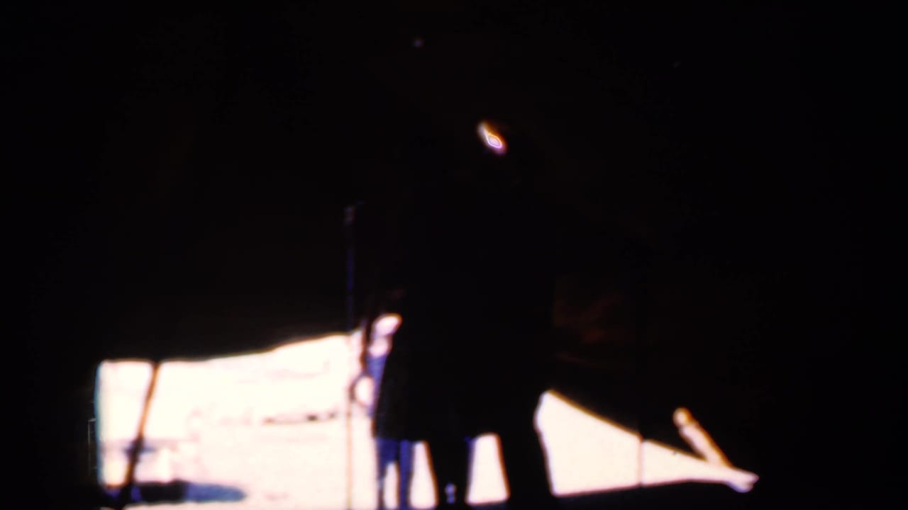 Silhouetted couple dancing on a tented stage beside a microphone stand.