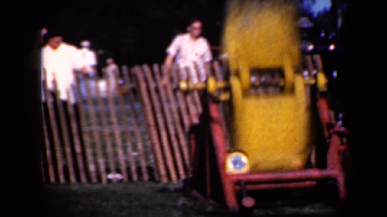 Yellow rail attraction beside a wooden fence with spectators standing behind it.