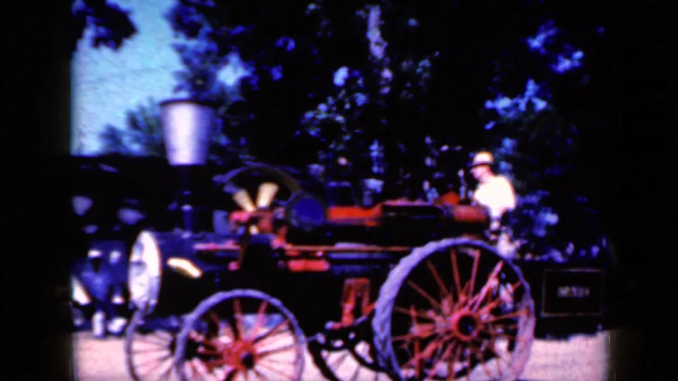 A side view in the Iowa 1959 clip shows the driver and large-wheeled steam-style vehicle against a tree-lined background.