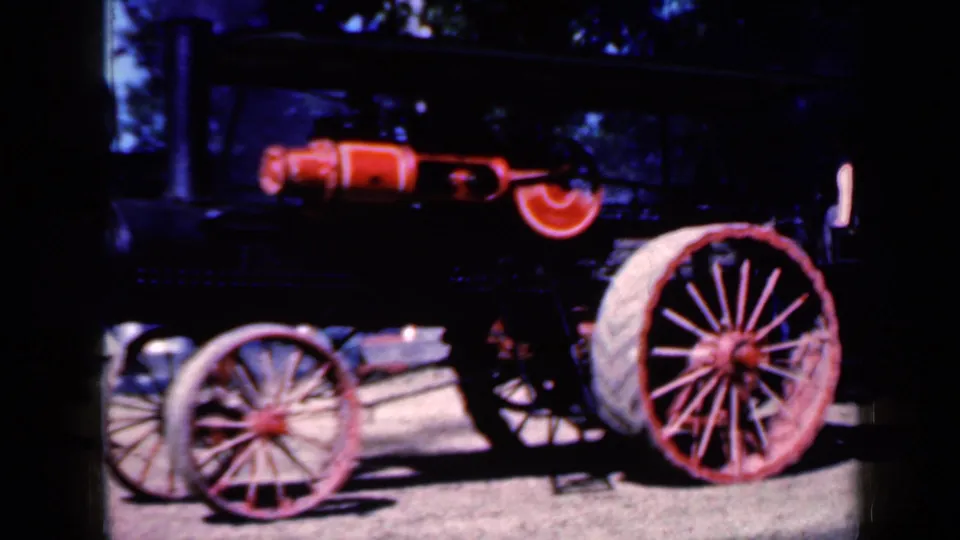 1959 Iowa frame with the steam traction engine filling much of the view, showing red-spoked wheels, boiler details and 8mm color grain.