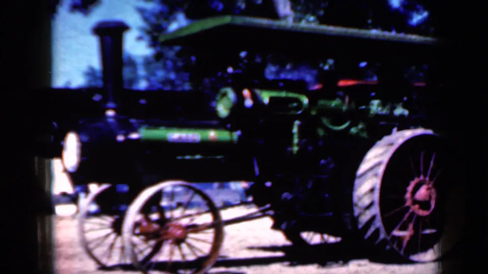 Closer 1959 Iowa frame showing a black and green steam tractor with a tall smokestack and red wheel details.