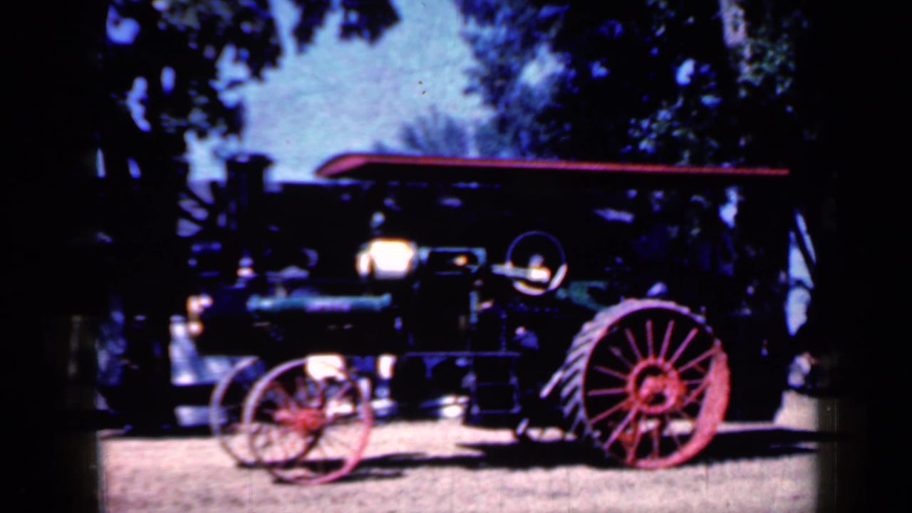 Side view of the same steam traction engine with red wheels and headlamp.