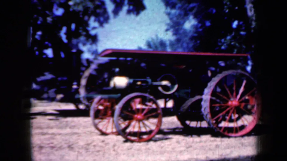 1959 Iowa 8mm frame emphasizing the engine's red wheels, dark body, canopy, and soft home-movie color.
