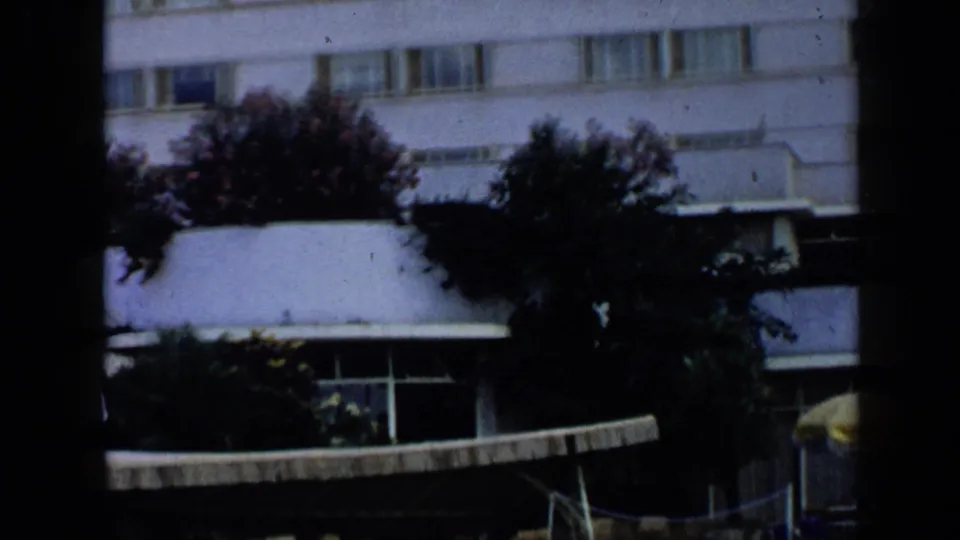 The final frame briefly shows a building exterior with rows of windows, plants, and an awning, likely near the restaurant setting in Venezuela footage.