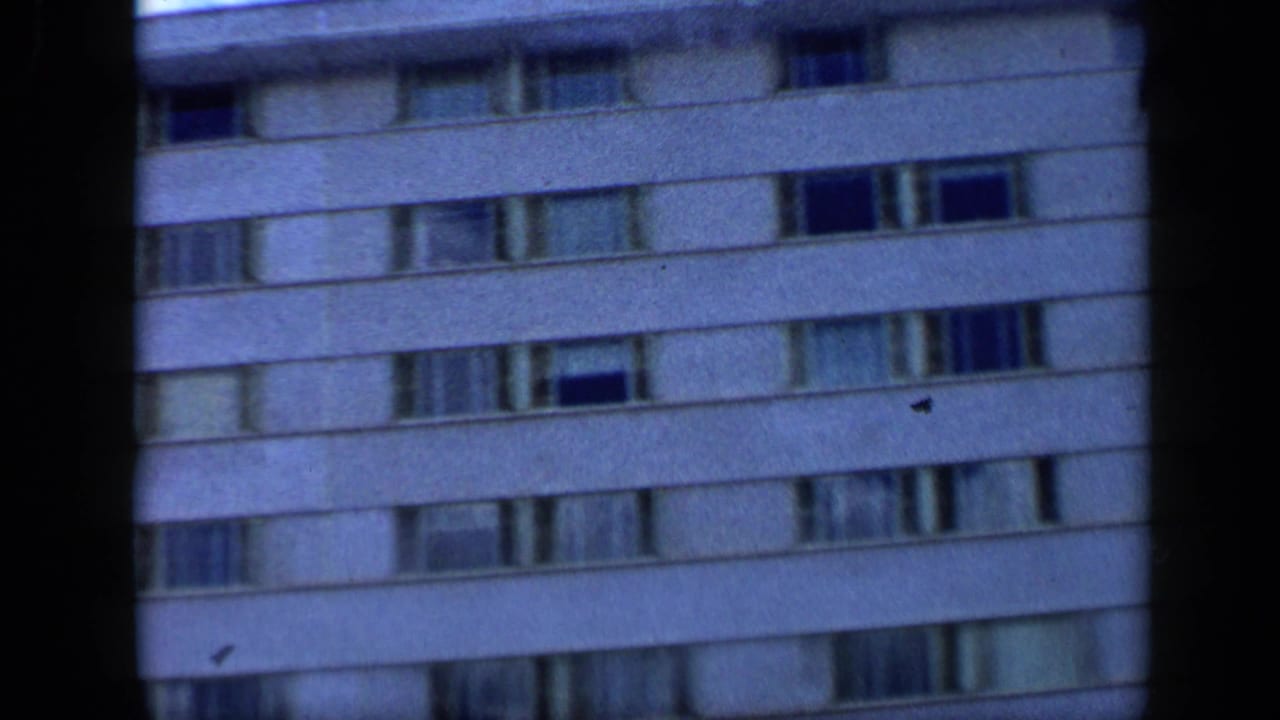 1959 Venezuela 8mm frame showing upper floors of the Tamanaco Hotel facade with horizontal window rows and soft focus.