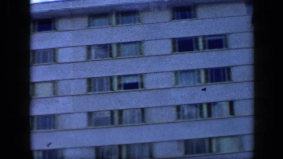 1959 Venezuela 8mm frame showing upper floors of the Tamanaco Hotel facade with horizontal window rows and soft focus.