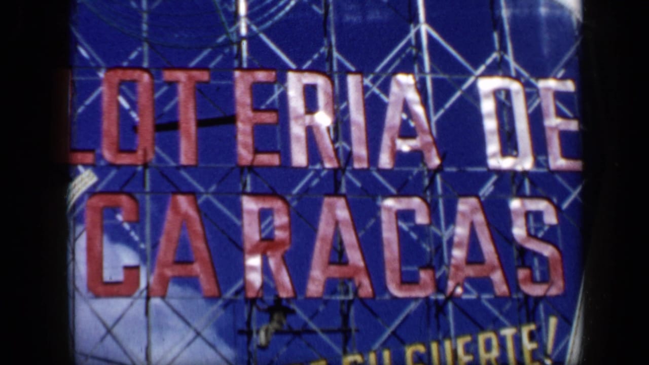 Blue Loteria de Caracas sign with red letters, scaffold poles, and a small worker figure.